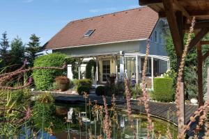 a house with a pond in front of it at Ferienhaus Bergblick in Redlham