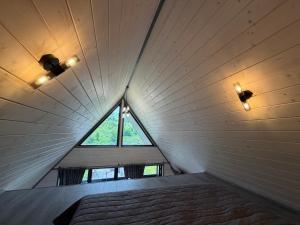 a bed in a room with a large window at А-фрейм У Ґазди in Synevyrsʼka Polyana