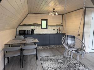 a kitchen and dining room with a table and chairs at А-фрейм У Ґазди in Synevyrsʼka Polyana