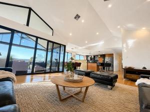 a living room with leather furniture and a table at Zig Zag Retreat - Hilltop Home With Stunning Views in Perth