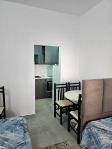 a kitchen and dining room with a table and chairs at Klea Rooms in Velipojë