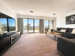a living room with a couch and a tv at Zig Zag Retreat - Hilltop Home With Stunning Views in Perth