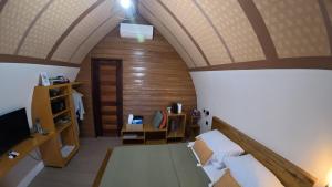 an attic room with a bed and a tv at Kubotique Beachfront Staycation in El Nido