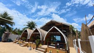 a building on a beach with some plants in it at Kubotique Beachfront Staycation in El Nido