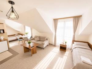 a living room with a bed and a couch at Villa Martii - Pokoje Rodzinne z Aneksami in Władysławowo