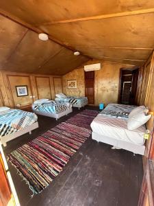 a group of three beds in a room with a rug at Free Beach Camp in Nuweiba‘ el Muzeinah