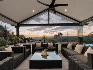 an outdoor living room with couches and a ceiling fan at Zig Zag Retreat - Hilltop Home With Stunning Views in Perth