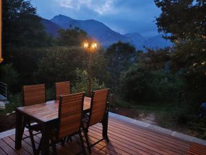 a wooden deck with a table and a street light at Chalet La montagne enchantée in San Damiano Macra