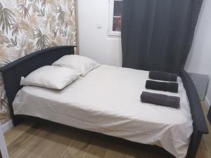 a bed with a black headboard and two pillows on it at Nature et calme d'Angers in Saint-Martin-du-Fouilloux