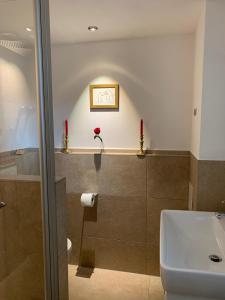 a bathroom with a sink and a toilet and red candles at Chalet im Chiemgau in Siegsdorf +24 photos