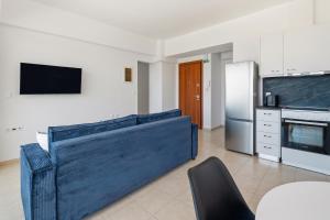 a living room with a blue couch in a kitchen at Celestial Luxury Residences in Asgourou