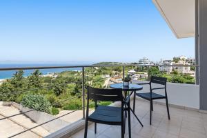 a balcony with a table and chairs and the ocean at Celestial Luxury Residences in Asgourou