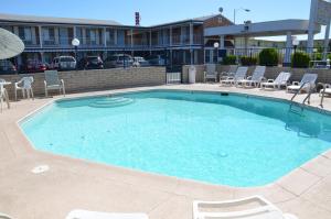 a large swimming pool with chairs and a building at University Inn in Tucson