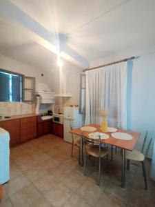 a kitchen with a table and chairs in a room at Coralia Nest Studio in Glossa