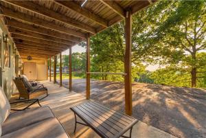 a porch with a bench and chairs on it at Ozark Skyline Retreat in Branson West