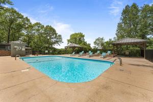 a swimming pool with chairs and a gazebo at Ozark Skyline Retreat in Branson West
