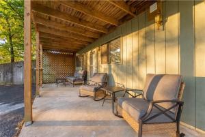 a covered porch with chairs and a table at Ozark Skyline Retreat in Branson West +14 photos