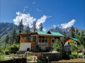 a house with a green roof and mountains in the background at EcoGlampLife in Kalgha