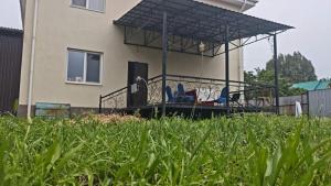 a house with a covered porch in a yard at Minsu in Mamyr +7 photos