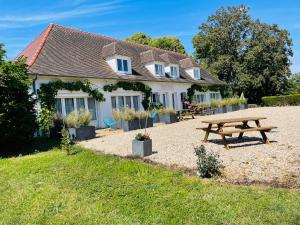 a house with a picnic table in front of it at Manoir de la Houlette in Saint-Pierre-du-Vauvray