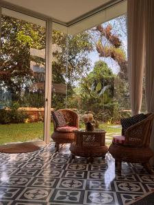 a porch with two chairs and a table and a window at Big Pvt Pool & Garden 3BHK Villa, Morjim Beach 10-14mts in Siolim