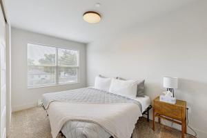 a white bedroom with a bed and a window at Mod Haus 1 in Kalispell