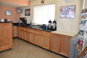 a kitchen with wooden cabinets and a counter top at University Inn in Tucson