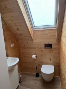a bathroom with a white toilet and a window at Gruszchatka 1 in Gruszów