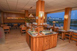a restaurant with tables and chairs and a counter at Hotel Haus Margarete am Meer in Norderney