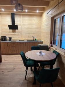 a dining room with a table and chairs and a kitchen at Gruszchatka 1 in Gruszów