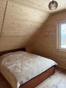 a bedroom with a bed in a wooden room at Gruszchatka 1 in Gruszów