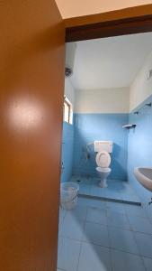 a bathroom with a toilet and a sink at Vedhas Holidays in Kodaikānāl