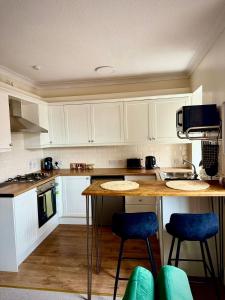 a kitchen with white cabinets and a table and chairs at Coorie in Inverness