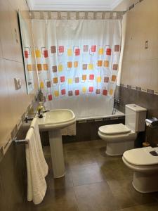 a bathroom with a sink and a toilet and a shower curtain at Casa Paula Ardales caminito del Rey in Ardales +36 photos