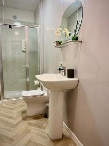 a bathroom with a sink and a toilet and a mirror at Coorie in Inverness