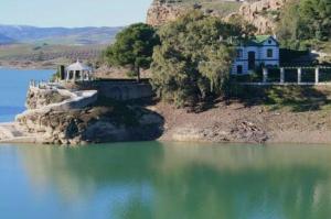 a house on a hill next to a body of water at Casa Paula Ardales caminito del Rey in Ardales