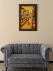 a couch in a room with a painting on the wall at Nizalia resorts in Patriata