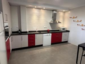 a kitchen with red and white cabinets and a sink at Casa Paula Ardales caminito del Rey in Ardales