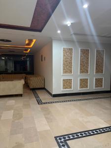 a lobby with a couch and a wall of windows at Nizalia resorts in Patriata +1 photo