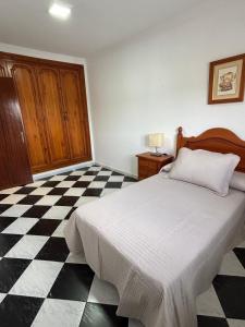 a bedroom with a bed and a black and white checkered floor at Casa Paula Ardales caminito del Rey in Ardales