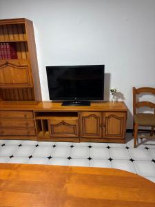 a flat screen tv sitting on top of a wooden entertainment center at Casa Paula Ardales caminito del Rey in Ardales