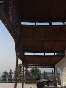 a wooden pavilion with a table and chairs on a patio at Nizalia resorts in Patriata