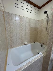 a bath tub in a bathroom with a shower at My Dream Wedding in Nathon Bay +1 photo