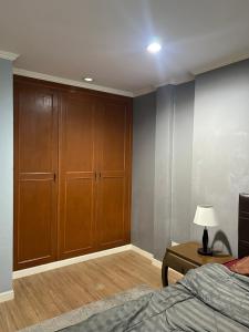 a bedroom with a bed and a wooden cabinet at My Dream Wedding in Nathon Bay