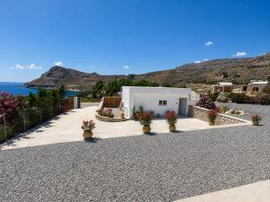 a white building with flowers inront of the ocean at Almyra Suites in Archangelos