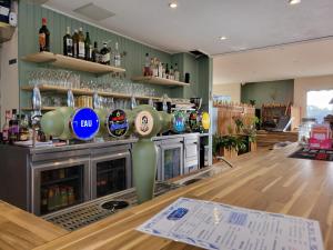 a bar with a counter with bottles of alcohol at Océan et Forêt in Les Mathes