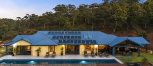 a house with a blue roof and a swimming pool at Zig Zag Retreat - Hilltop Home With Stunning Views in Perth