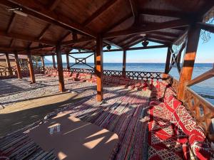 a pier with red chairs on the beach at Free Beach Camp in Nuweiba‘ el Muzeinah