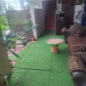 a living room with green carpet and a table at Hotel good vibes in Coimbatore