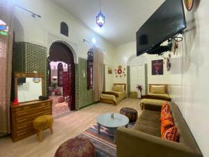 a living room with a couch and a flat screen tv at Dar Nassiri in Rabat